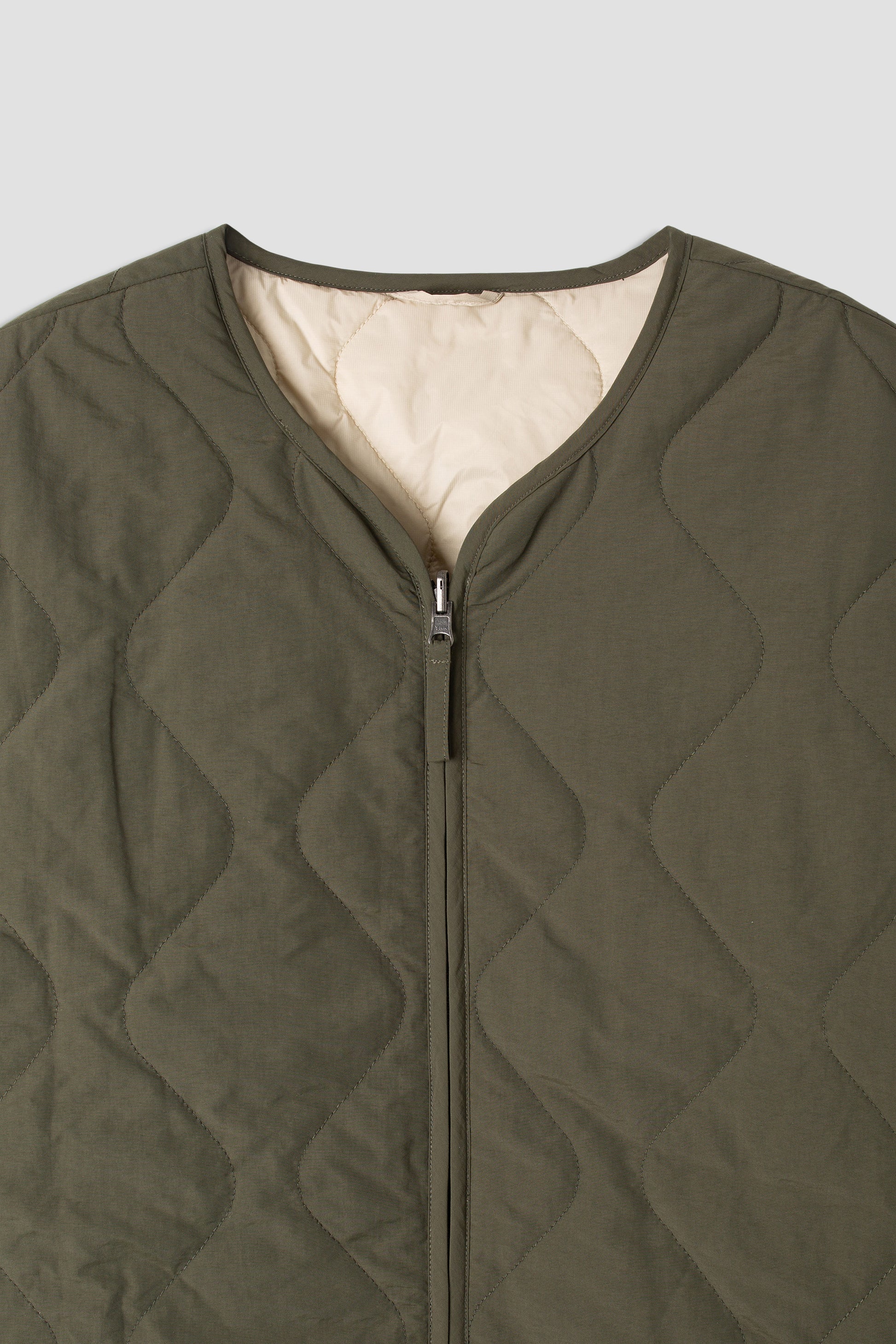 Close-up of olive quilted jacket zipper