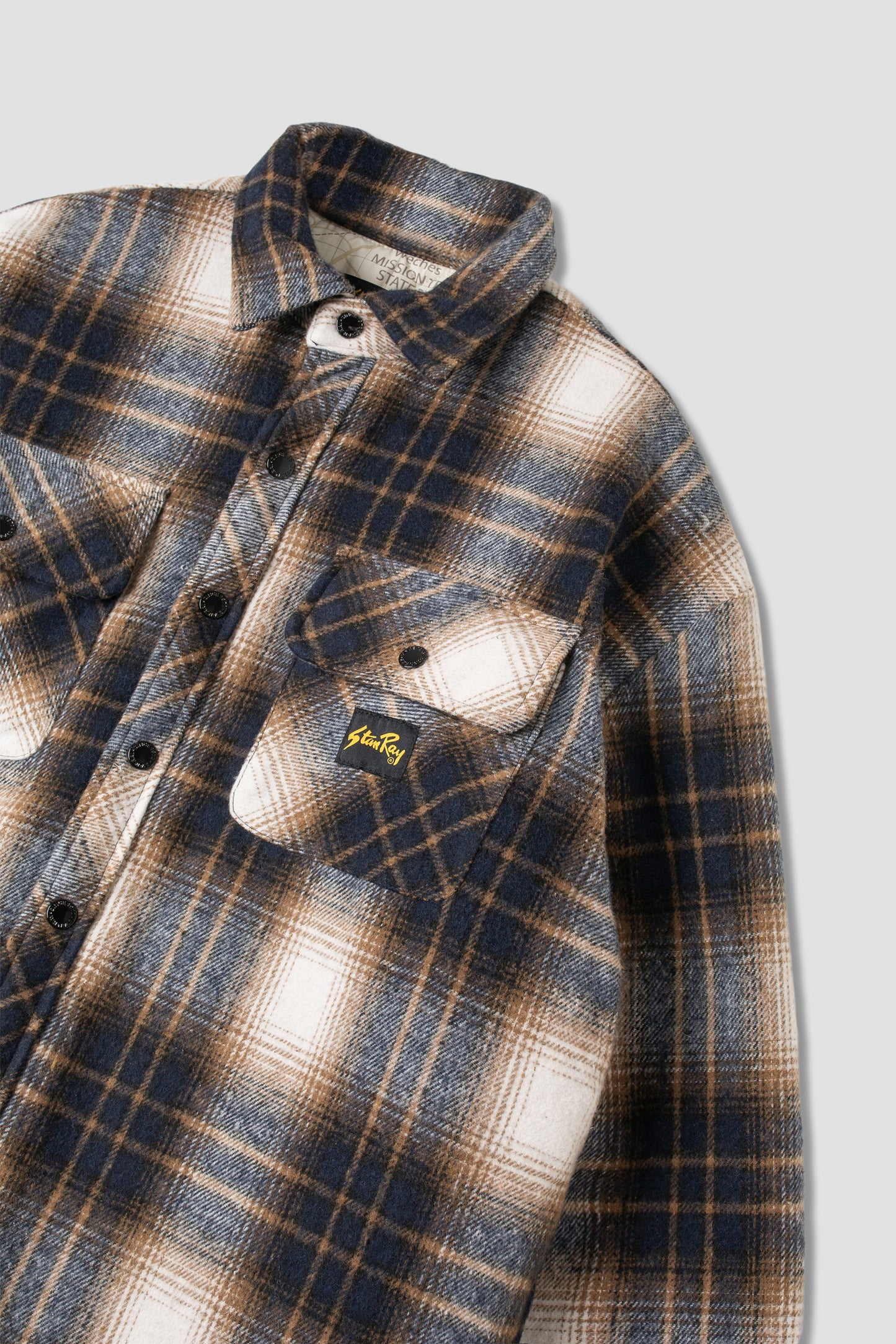 Angled view of navy plaid quilted overshirt