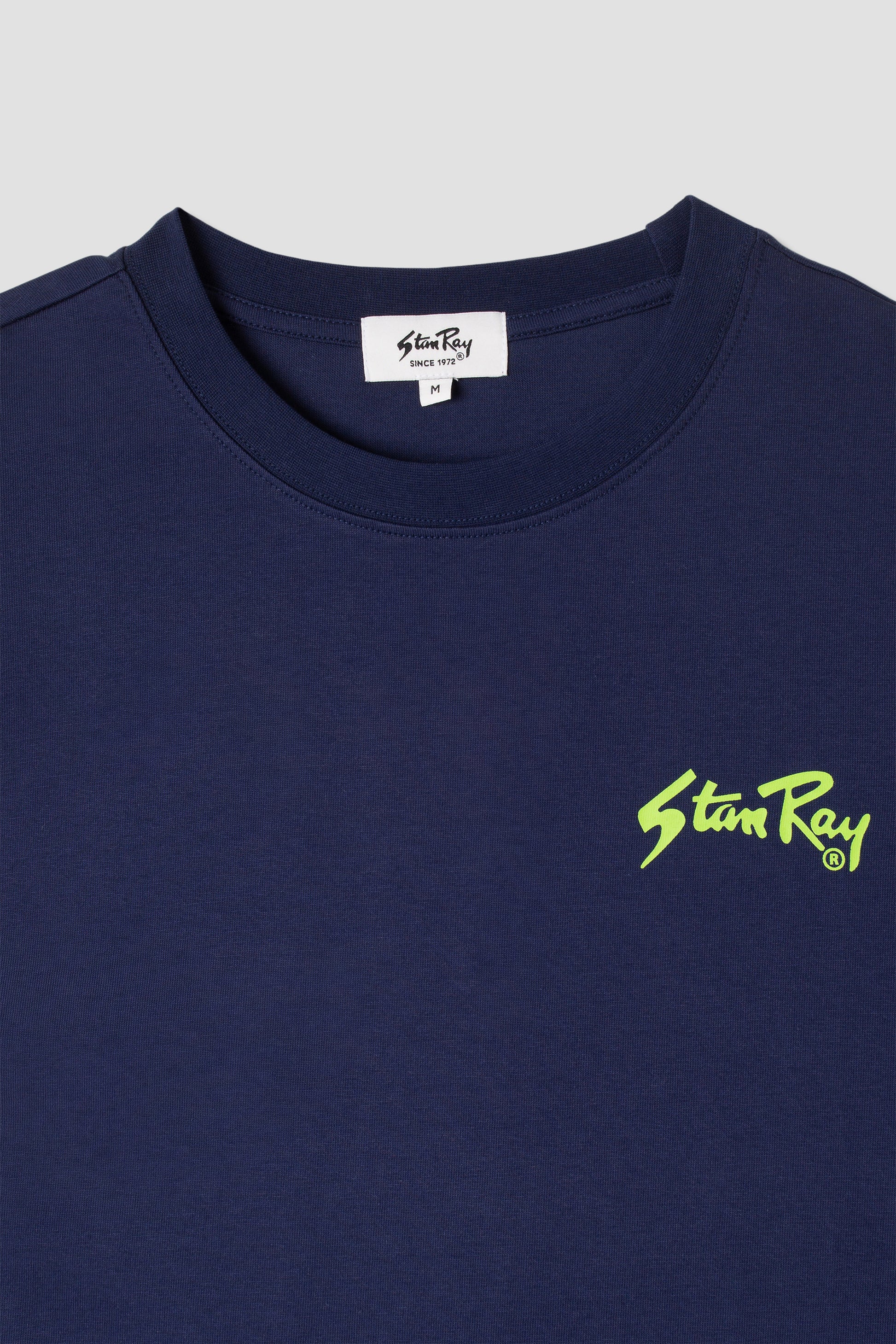 Close-up of Stan OG Tee navy with lime green logo