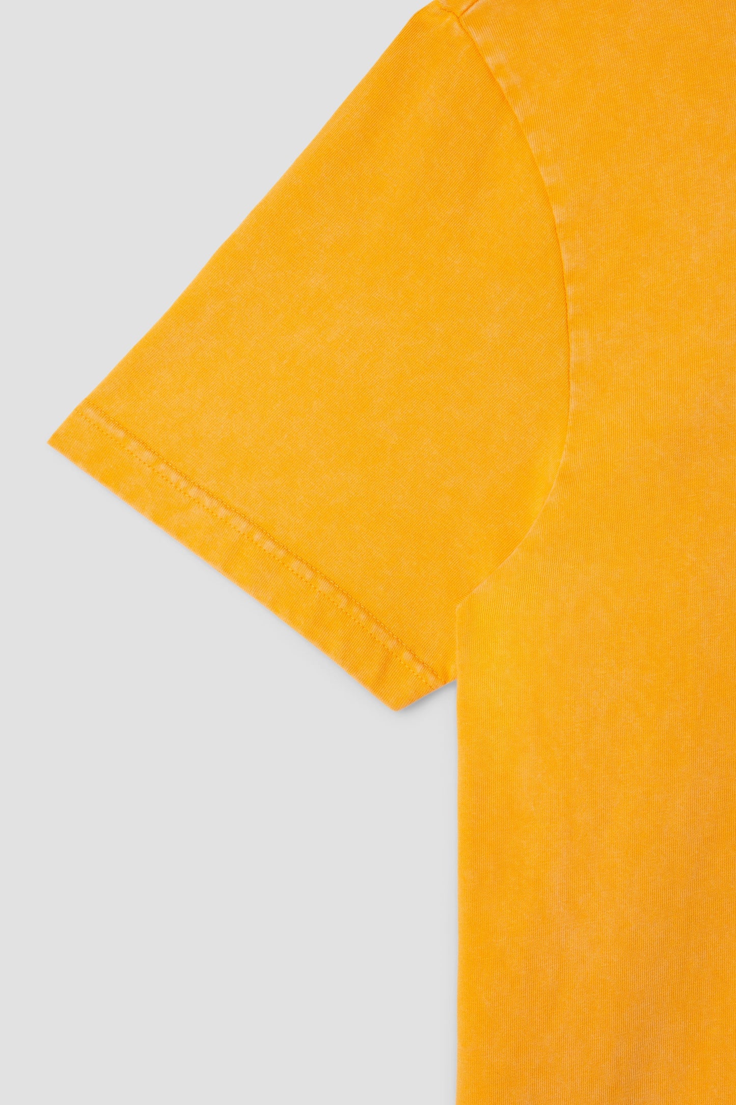 Detail of Stan OG Tee sleeve in washed orange