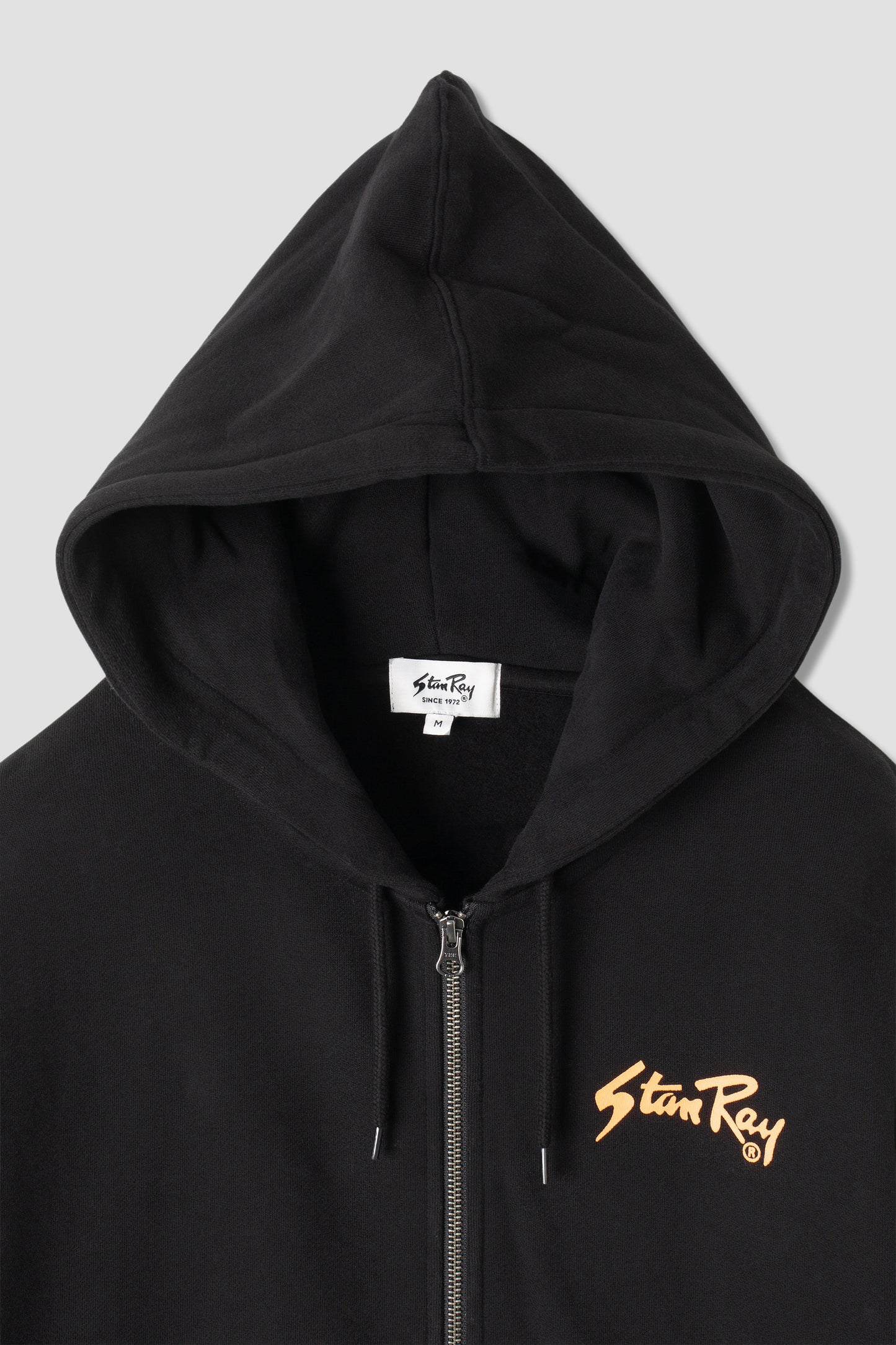 Close-up of Stan OG Zip Hood hood and logo detail