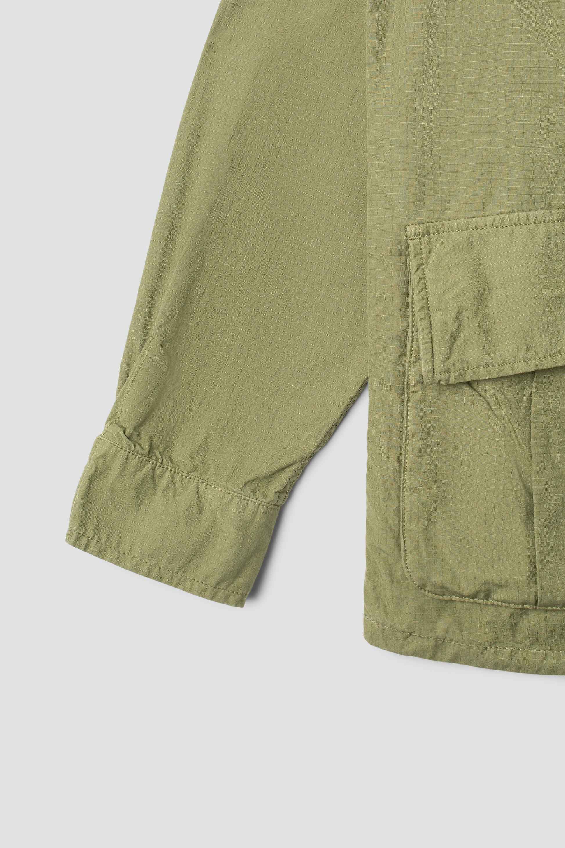 Detail of sleeve and pocket on olive ripstop jacket