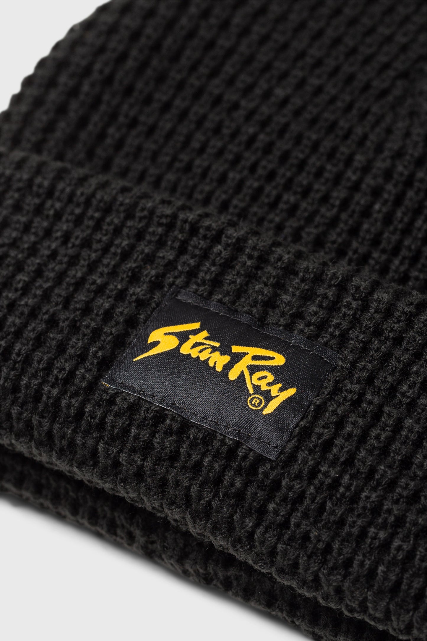 Close-up of Stan Ray logo on black waffle beanie