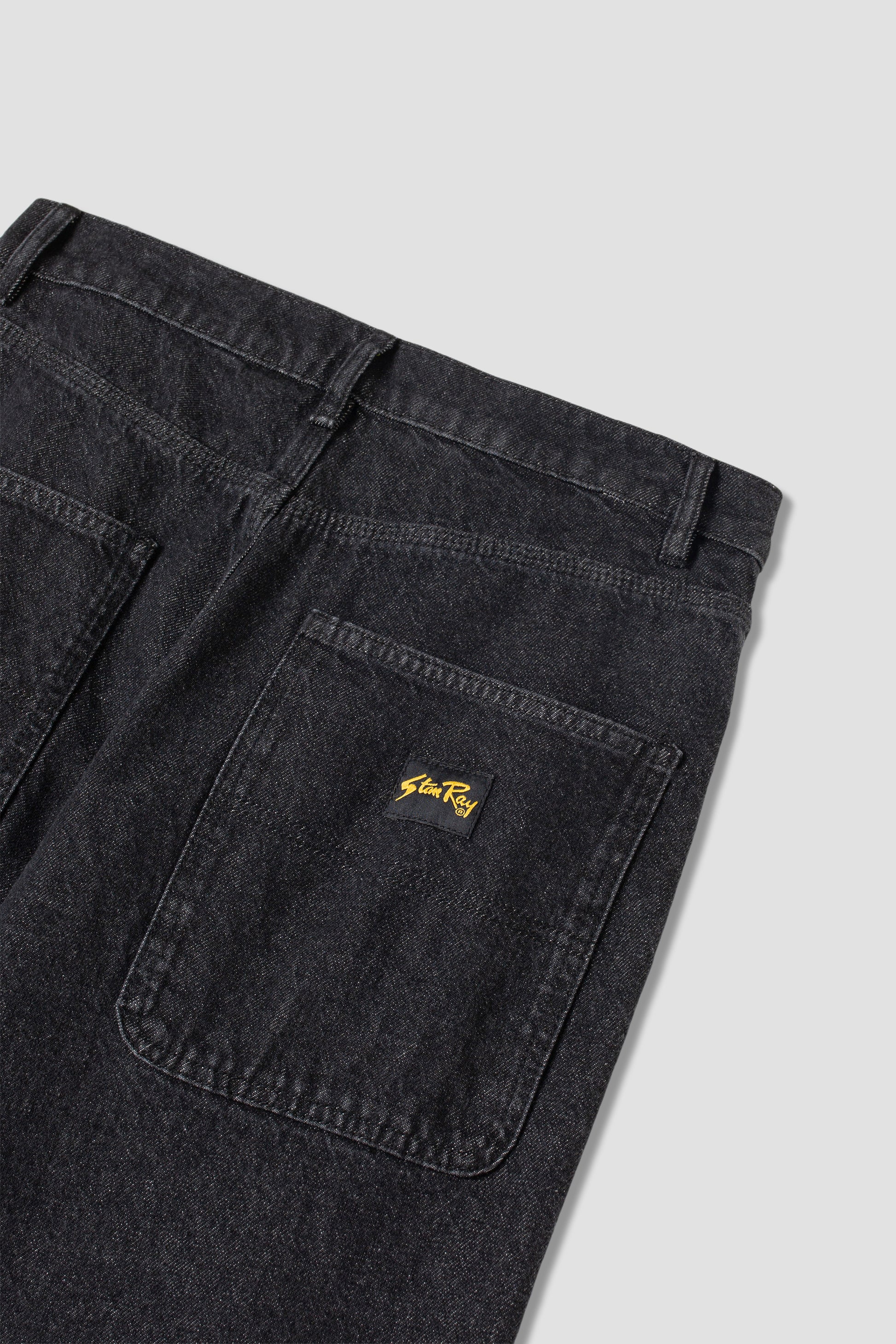 Detail of back pocket on charcoal denim jeans